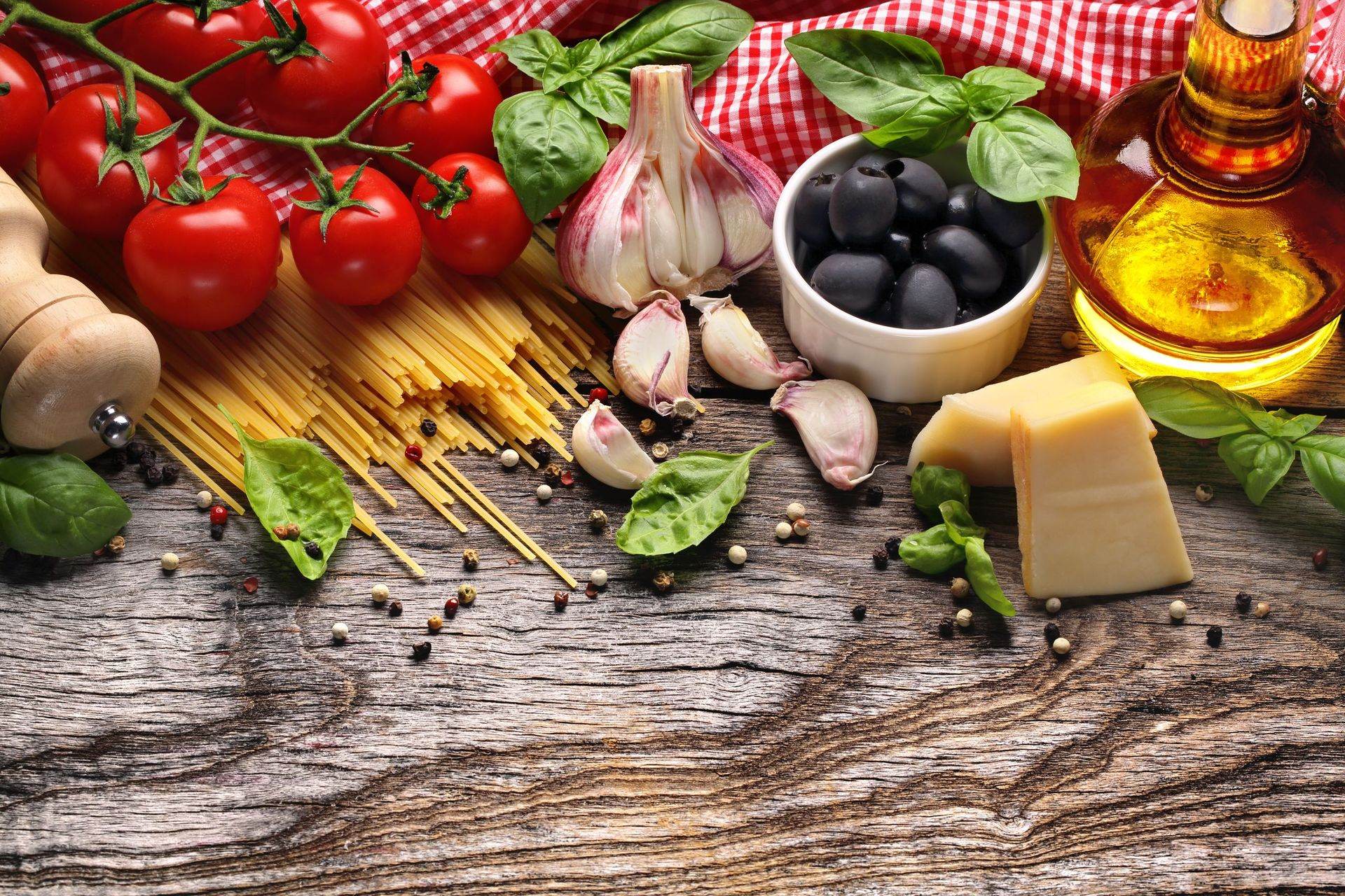 Tomaten, Basilikum, Olivenöl und Spaghetti auf einem Holztisch