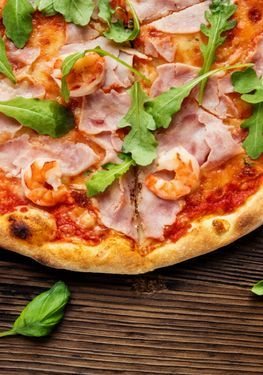 Pizza Margherita mit Schinken, Crevetten und frischem Rucola