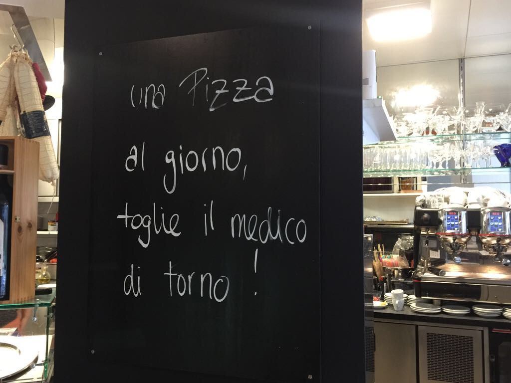Wandtafel mit dem Spruch «Una pizza al giorno, toglie il medico di torno»